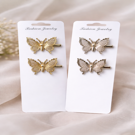 Butterfly-shaped hair clips on white cards with 'Fashion Jewelry' text, on a beige fabric background.