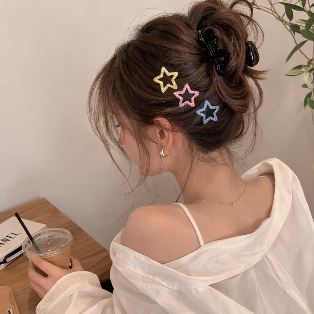 Kids colourful hair ties, star clips, and satin scrunchies laid out together