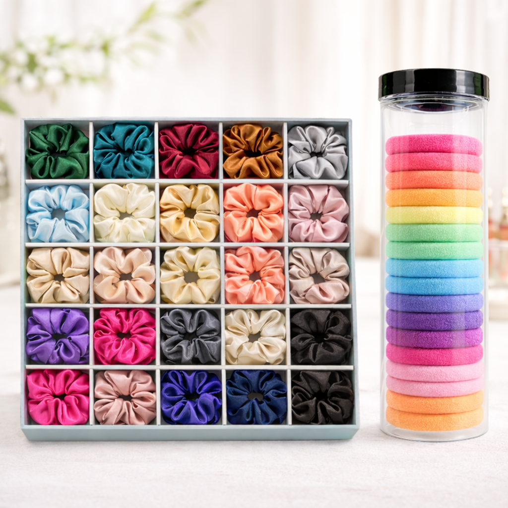 Set of colorful hair ties in a box and tube on a light background