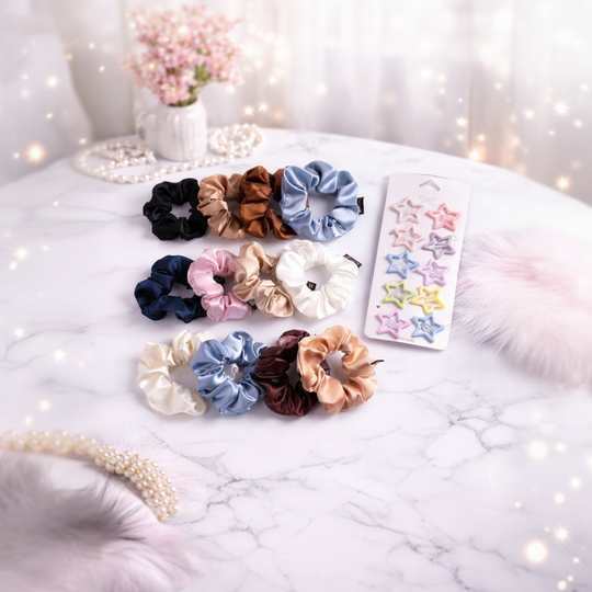 Set of colorful scrunchies and star-shaped hair clips on a marble surface with decorative elements.